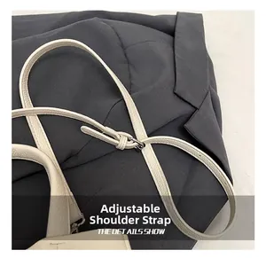 Détail d'une bandoulière réglable en cuir blanc à motif lychee avec boucle argentée