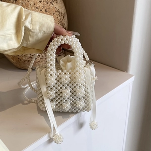 Sac à main perlé fait main avec pochette en satin sur une surface minimaliste