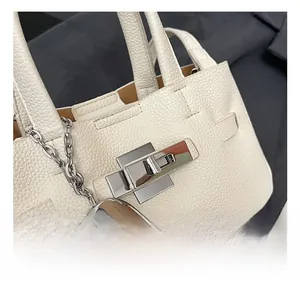 Détail du fermoir carré argenté et du cuir grainé blanc sur ce sac à main vintage