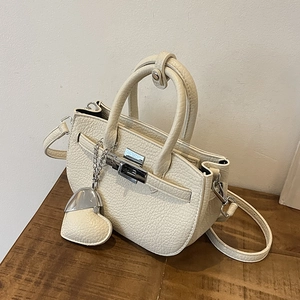Borsa a mano trapezoidale beige in pelle con chiusura girevole argento e ciondolo a cuore
