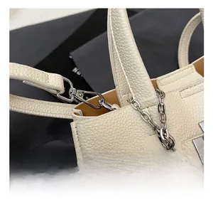 Détail du crochet en métal argenté et de la bandoulière en cuir grainé beige