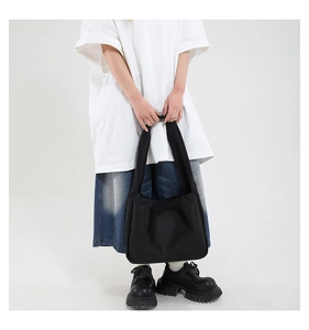 Vue street style d'un sac à bandoulière en maille noire avec une jupe en jean
