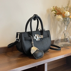Elegante borsa a mano nera in pelle a grana con chiusura argento e ciondolo
