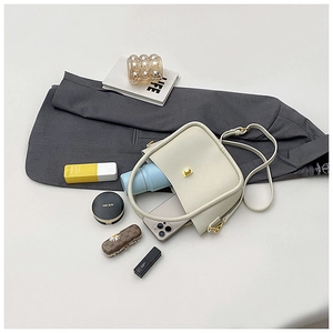 Interior view of beige leather satchel bag showing smartphone and cosmetic storage