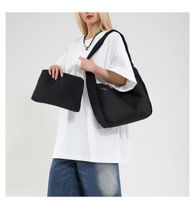 Détail du sac bandoulière noir en toile plissée avec poche filet et pochette