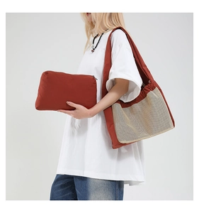Sac bandoulière en toile rouge brique avec poche en filet beige et pochette zippée