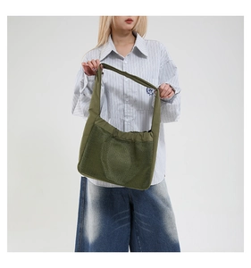 Détail du sac bandoulière plissé en résille vert armée avec large bandoulière assortie