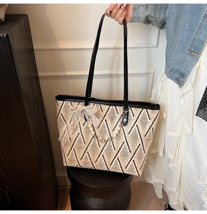 Close-up of geometric woven tote bag with lace bow and pearl chain decorative detail