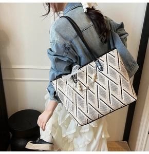 Detailed view of the woven tote bag texture with elegant pearl and lace charm decoration
