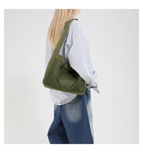 Vue détaillée du sac bandoulière en maille vert armée porté à l'épaule