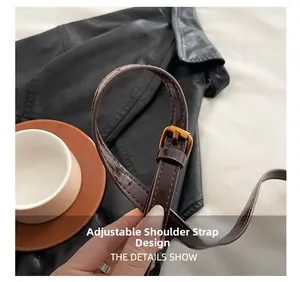 Detail view of adjustable dark brown leather shoulder strap with gold metal buckle