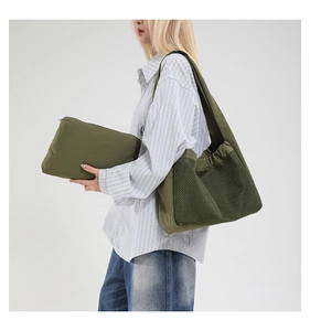Détail du sac bandoulière plissé vert olive et sa pochette zippée assortie en nylon
