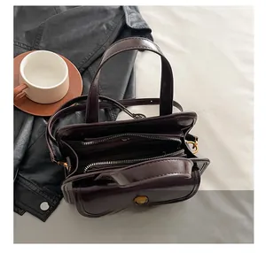 Detailed interior of a vintage brown leather handbag showing double zipper compartments