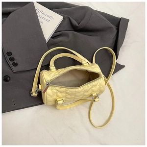 Détail du sac Boston jaune clair avec matelassage cœur et ouverture zippée montrant l'intérieur