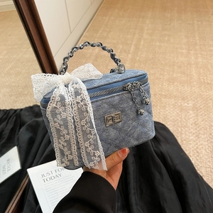 Quilted denim box bag with white lace bow and silver chain handle in retro blue style