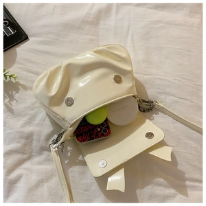 Interior view of cream pleated crossbody bag showing space for phone and makeup items