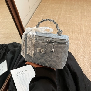 Light blue quilted denim box bag with metal chain handle and lace bow decoration