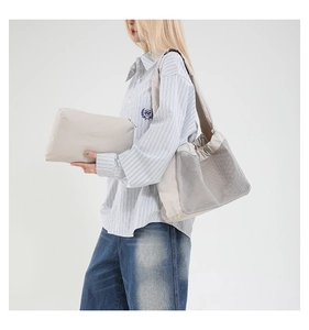 Détail du sac bandoulière en maille plissée beige clair avec petite pochette zippée
