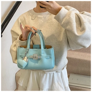 Détail d'un sac à main en cuir bleu clair à motif litchi avec fermoir pivotant argenté