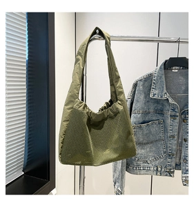 Détail du sac à bandoulière en maille vert olive avec cordon de serrage et large bandoulière