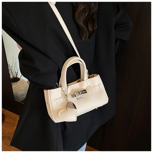 Détail du sac à main blanc crème en cuir grainé avec fermoir rotatif argenté