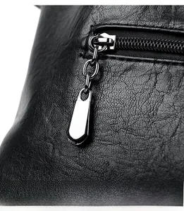 Close-up of premium black lychee leather texture and silver metallic zipper detail