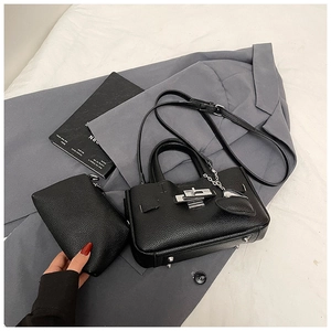 Détail d'un ensemble cabas et pochette en cuir grainé noir avec pendentif cœur argenté