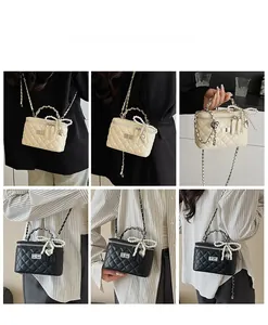Detail of quilted chain bag with pearl bow handle and metal heart pendant accessory