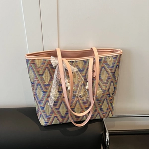 Colorful woven tote bag with geometric pattern, pink handles, and pearl bow detail