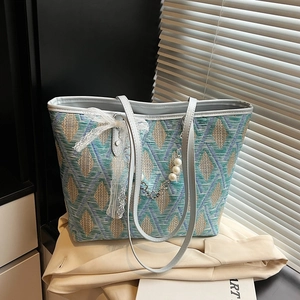 Chic woven tote bag with geometric diamond patterns and lace trim on a blazer