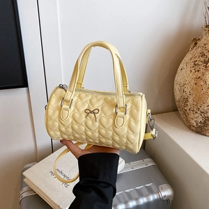Sac cylindrique jaune clair matelassé à cœurs avec nœud métallique et bandoulière