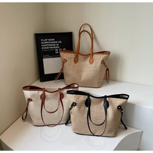 Detail of large woven straw tote bags with leather straps and drawstring side adjustment