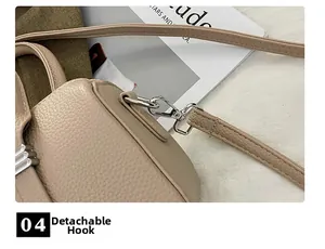Detail of silver detachable metal hook and pebble leather texture on a beige handbag