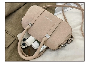Interior detail of beige lychee leather bag showing organized daily essentials and strap