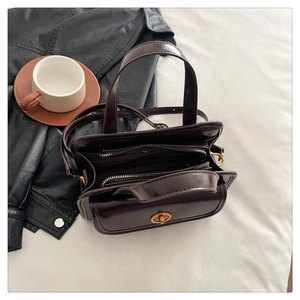 Top view of shiny dark coffee handbag with three-layer storage and metal turn-lock detail