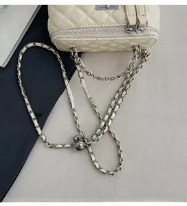 Detail of cream quilted bag showing adjustable silver ball on woven chain strap
