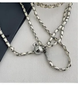 Detail of cream leather chain strap with silver diamond quilted metal adjustment ball