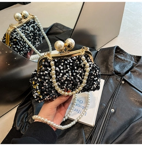 Gros plan sur la pochette de soirée à paillettes noires avec anse en perles et fermoir doré