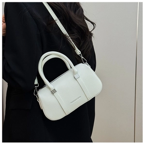 Detail of white lychee texture leather handbag with silver hardware and fashion lettering