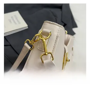 Close-up of premium gold hardware hook on a beige minimalist shoulder bag