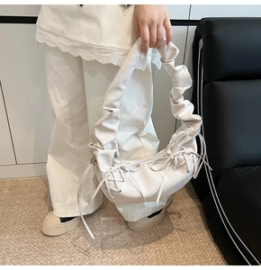 Détail du sac à main blanc avec nœud décoratif et texture en cuir PU plissé