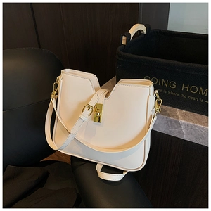 Detail of cream white leather tote featuring gold metal lock and adjustable shoulder strap