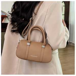 Close-up of camel litchi grain leather bag with silver hardware and fashion text engraving