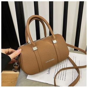 Detail of brown litchi pattern leather cylinder bag with silver hardware and logo