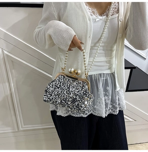 Détail d'un sac de soirée argenté à paillettes avec bandoulière et fermoir en perles