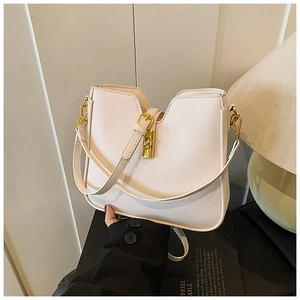 Detailed view of the elegant beige handbag with a unique V-cut opening and golden clasp lock