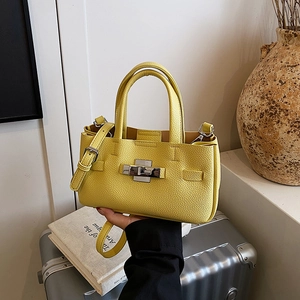 Sac à main jaune en cuir grainé avec fermoir rotatif argenté et bandoulière