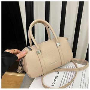 Close-up of beige lychee grain leather bag with silver buckle and fashion branding
