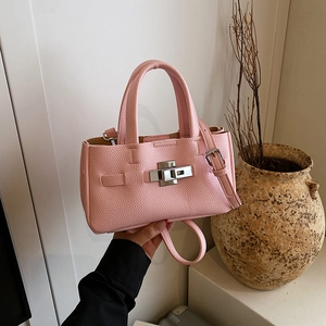 Sac à main rose en cuir grainé avec fermoir argenté et bandoulière amovible