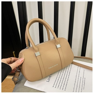 Detail of khaki pebbled leather mini Boston bag featuring silver hardware and top handles